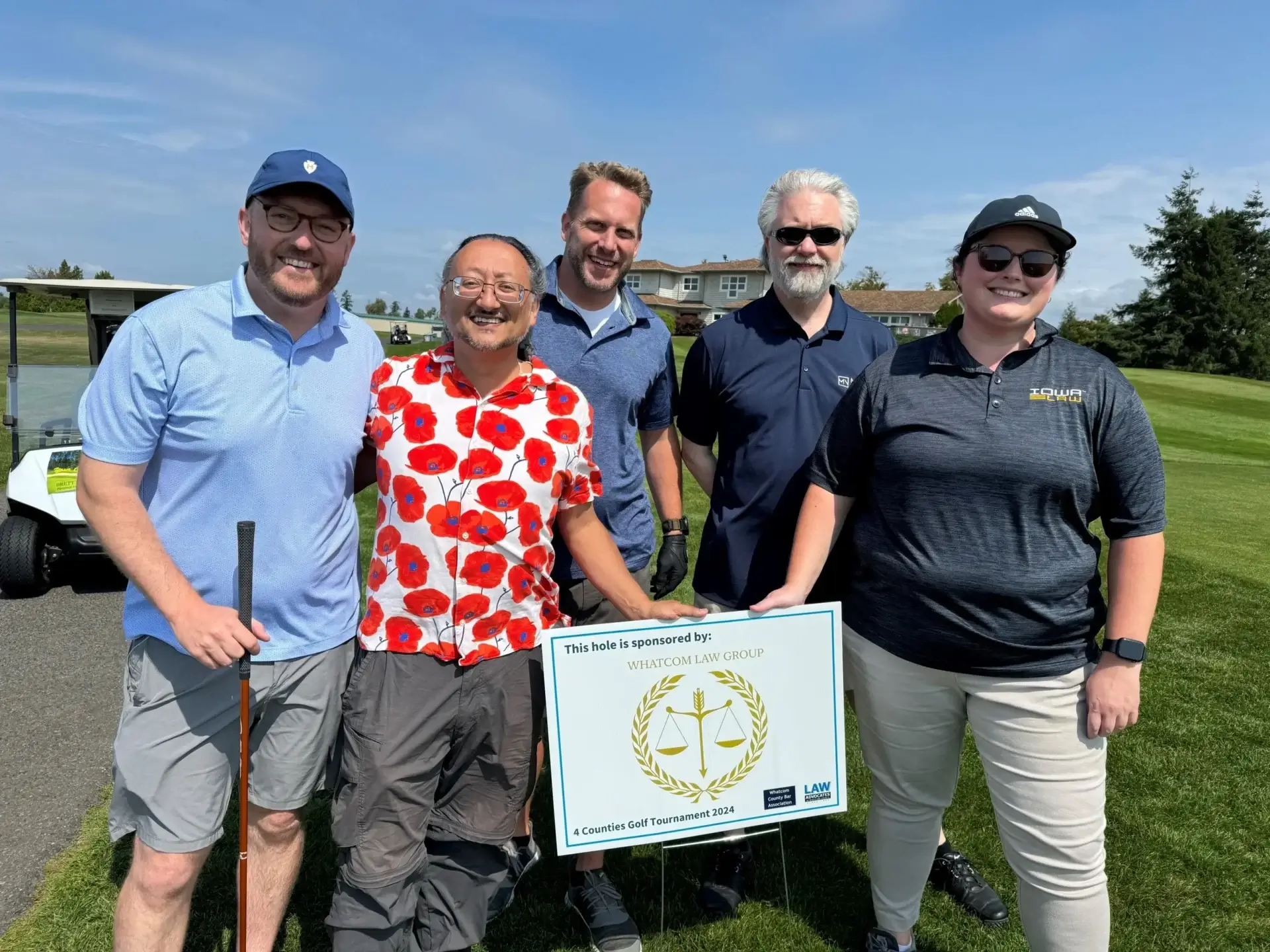 Group smiling on a sunny golf course.