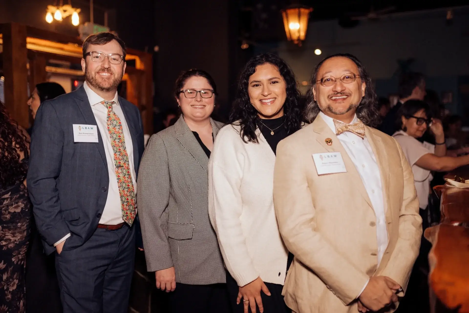 Group of four people smiling at event.
